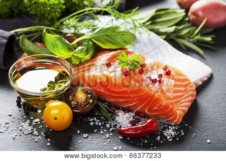 Delicious  portion of fresh salmon fillet  with aromatic herbs, spices and vegetables - healthy food, diet or cooking concept