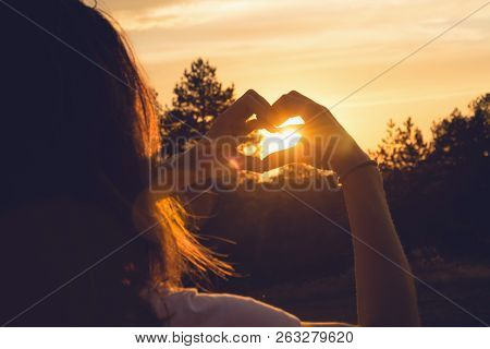 Woman Makes Heart With Hands In Sunset. Healthy People  Lifestyle. Woman Makes Heart With Hands. Nat