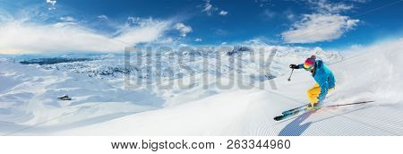 Alpine skier skiing downhill, panoramic format. Winter sports and leasure activities