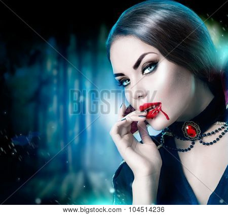 Beautiful Halloween Vampire Woman portrait. Beauty Sexy Vampire lady with blood on her mouth looking at camera. Fashion Art design. Attractive model girl in Halloween costume and make up 