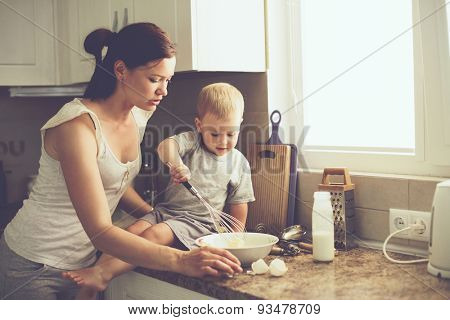 Mom with her 2 years old child cooking holiday pie in the kitchen to Mothers day, casual lifestyle photo series in real life interior