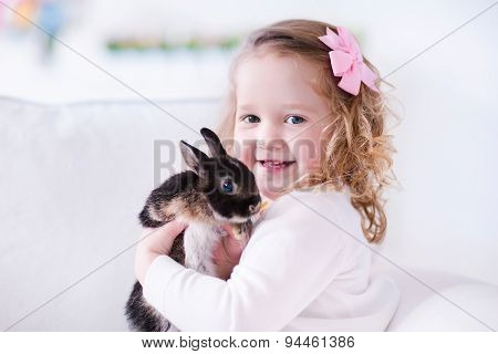 Little Girl Playing With A Real Pet Rabbit