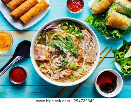 colorful vietnamese pho bo with beef and spring rolls