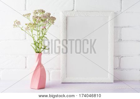 White frame mockup with creamy pink flowers in swirled vase. Empty frame mock up for presentation design.