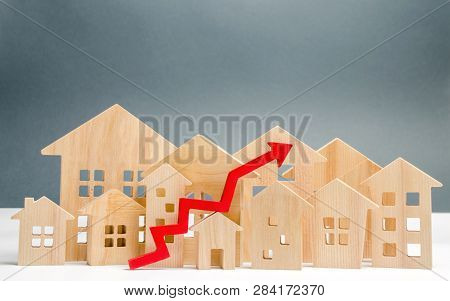 Wooden Houses And Up Arrow. The Concept Of Real Estate Market Growth. The Increased In Housing Price