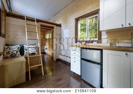 Interior design of a dining room and kitchen in a tiny rustic log cabin.