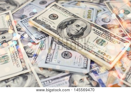 A stack of money. Heap of one hundred dollar bills on money background. Fake money. Shallow depth of field. Selective focus.