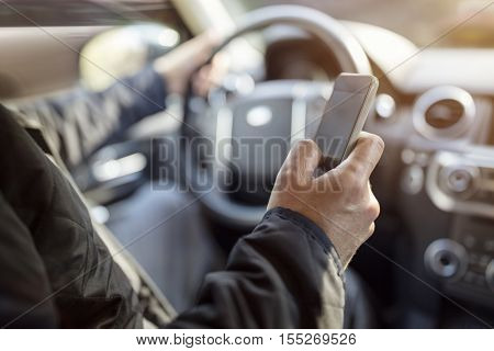 Using a phone in a car texting while driving concept for danger of text message and being distracted