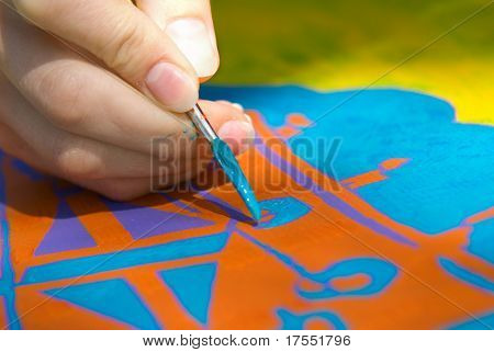 Artist fingers with brush, doing artwork