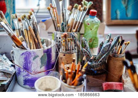 Artist workplace background. Art tools. Old dirty Paints background. Colorful artist palette. Soft toned. Creativity visual art concept. Art and craft. Closeup