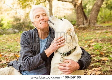 Senior man with his dog in park on an autumns day