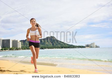 Sport running fitness woman jogging on beach run. Female athlete runner jogger training living healthy active exercise lifestyle exercising outdoor on Waikiki Beach, Honolulu, Oahu, Hawaii, USA. 