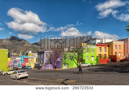 Cape Town, South Africa, August 17, 2018: A Street Scene, With Multi-colored Houses, People And Vehi