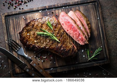 Fresh grilled meat. Grilled beef steak medium rare on wooden cutting board. Top view.