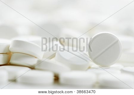 Pharmacy theme, Heap of white round medicine tablet antibiotic pills. Shallow DOF