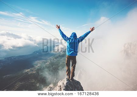 Man Traveler on mountain summit enjoying aerial view hands raised over clouds Travel Lifestyle success concept adventure active vacations outdoor happiness freedom emotions