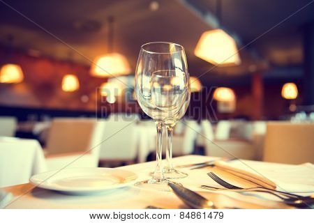 Served dinner table in a restaurant. Restaurant interior. Cozy restaurant table setting. Defocused background