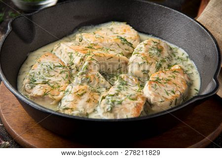 Chicken Fillet Or Turkey Breast In Creamy Sauce With Dill And Garlic, In Cast Iron Black Pan On Dark