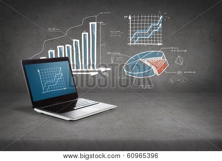 technology and advertisement concept - laptop computer with graph on screen