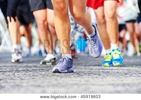 Marathon running race people competing in fitness and healthy active lifestyle feet on road