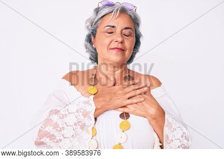 Senior hispanic grey- haired woman wearing casual hippie clothes smiling with hands on chest, eyes closed with grateful gesture on face. health concept. 