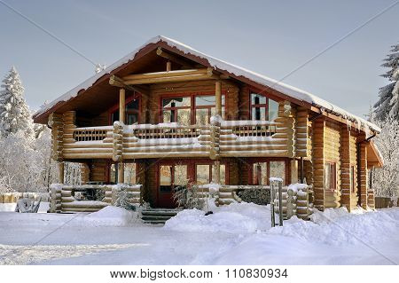 Log House Covered In Snow During Winter.