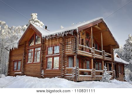 Log Home Winter With Large Windows, Balcony And Porch, Daytime.