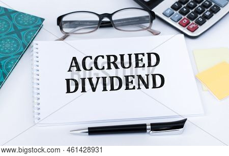 Accrued Dividend, Text On A Notepad Page. Two Notebooks On The Table