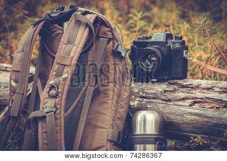 Lifestyle hiking camping equipment retro photo camera backpack and thermos outdoor