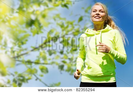 fitness, people and healthy lifestyle concept - happy young female runner jogging outdoors