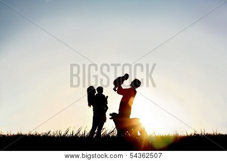 Silhouette Of Happy Family And Dog