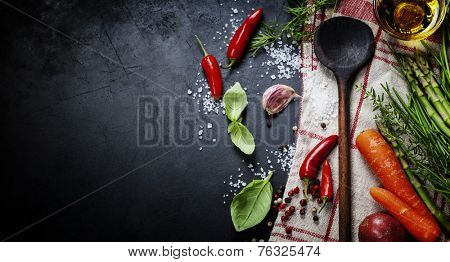 Wooden spoon and ingredients on dark background. Vegetarian food, health or cooking concept.