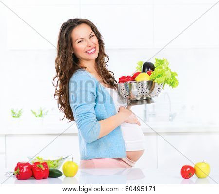 Pregnant Young Woman Cooking vegetables. Healthy Food - Vegetable Salad. Diet. Dieting Concept. Healthy Lifestyle. Cooking At Home. Prepare Food