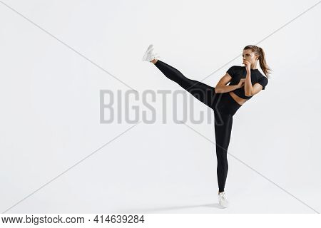 Determined Sport Woman In Activewear Do High Kick, Tae-bo Martial Arts Exercises Isolated On White B