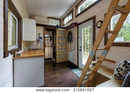 Interior design of a dining room and kitchen in a tiny rustic log cabin.