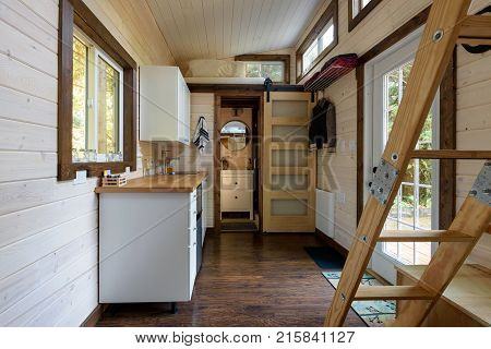 Interior design of a dining room and kitchen in a tiny rustic log cabin.