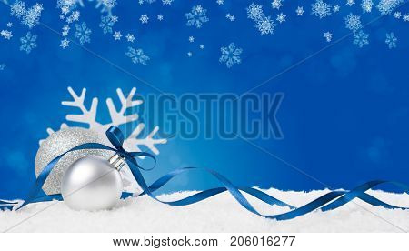 Christmas background in blue. Snow flakes and christmas balls with ribbon and copyspace. Xmas background with snowflakes, balls and ribbon. Write it on whatever you need.