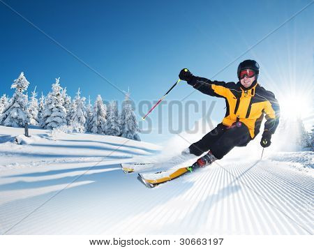 Skier in mountains, prepared piste and sunny day