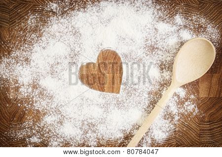 Heart of white flour on a wooden board. Cooking with love. Holiday backing background. Eco food and home cooking. 