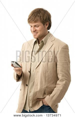 Young man writing text message on smart phone, looking at screen, smiling. Isolated  on white.?