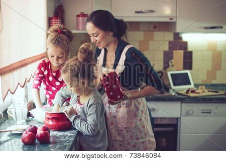 Mother with her 5 years old kids cooking holiday pie in the kitchen to Mothers day, casual lifestyle photo series in real life interior