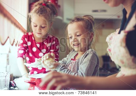 Mother with her 5 years old kids cooking holiday pie in the kitchen, casual lifestyle photo series in real life interior