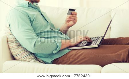 technology, shopping, banking, home and lifestyle concept - close up of man with laptop computer and credit card at home