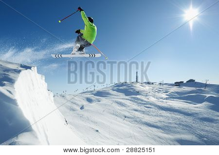 Young skiing man - skier at jump in beautiful alpen snow paradise