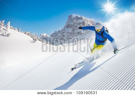 Skier skiing downhill in high mountains