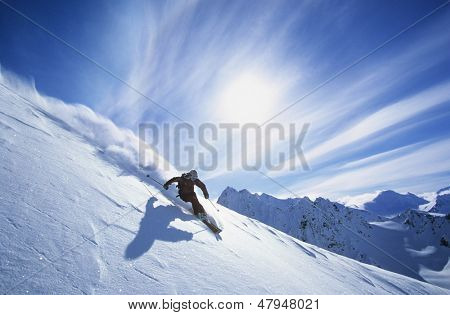 Full length of skier skiing on fresh powder snow