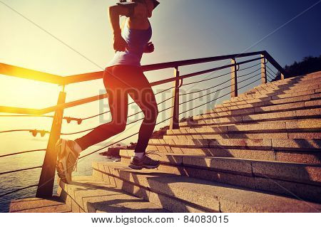 healthy lifestyle sports woman running up on stone stairs sunrise seaside