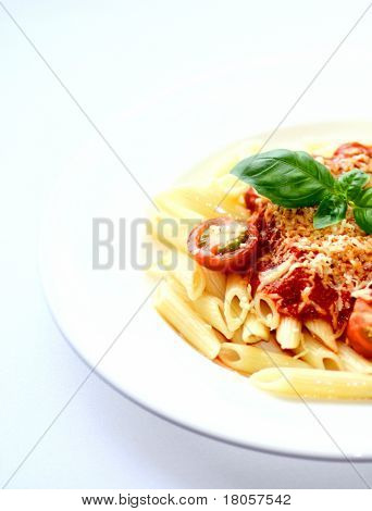 Een bord pasta penne buizen met rijke tomatensaus en beregening van geraspte kaas, garneer met ch