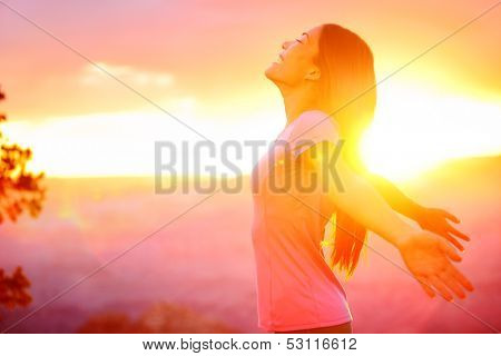 Free happy woman enjoying nature sunset. Freedom, happiness and enjoyment concept of beautiful multiracial Asian Caucasian girl in her 20s. Image from Grand Canyon, United States.