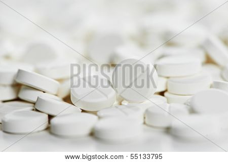 Pharmacy theme, Heap of white round medicine tablet antibiotic pills. Very Shallow DOF